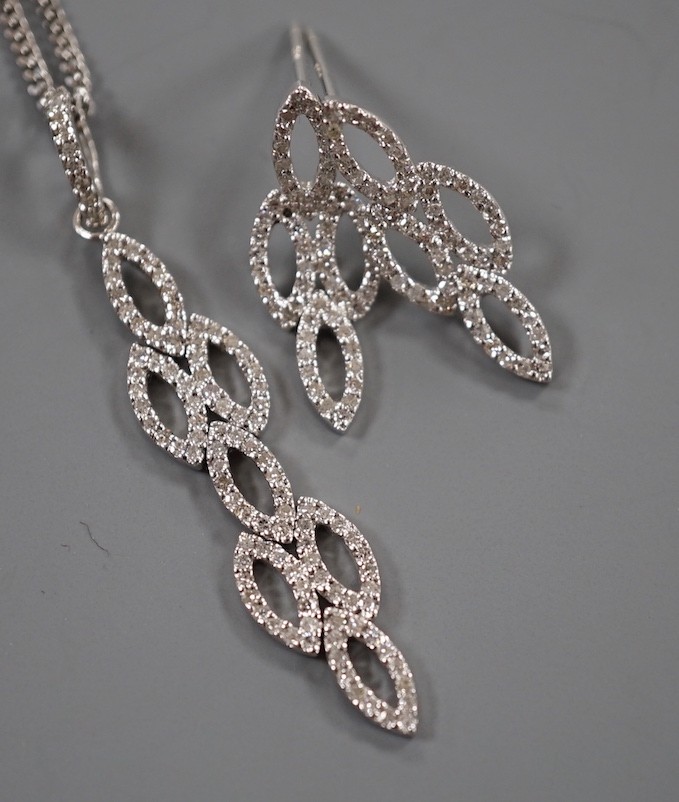 A modern 18ct white gold and diamond chip set septuple oval cluster pendant, overall 42mm, on an 18ct white gold fine link chain, 39cm and a pair of matching earrings, 21mm, gross weight 7.4 grams.